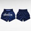 Muay Thai Shorts Supplier showing front and back view of navy blue shorts with Thai text and lion design