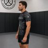 Side profile of athlete wearing black spider web rash guard and matching shorts by Reedot Sports